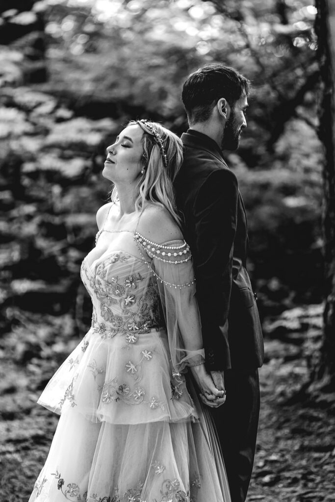 a couple stands back to back before their first look holding hands during their north cascades elopement