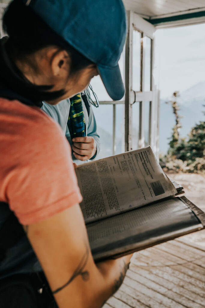 an over the shoulder shot of a log book from a fire tower in the north cascades 