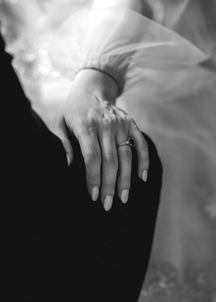 a close up shot of a brides hand on the knee of her groom 